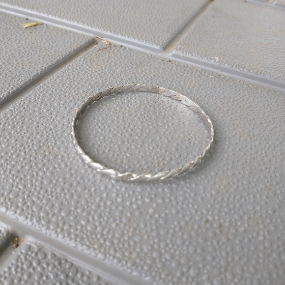 Women's thin silver tone braided bangle bracelet. - Picture 2 of 3